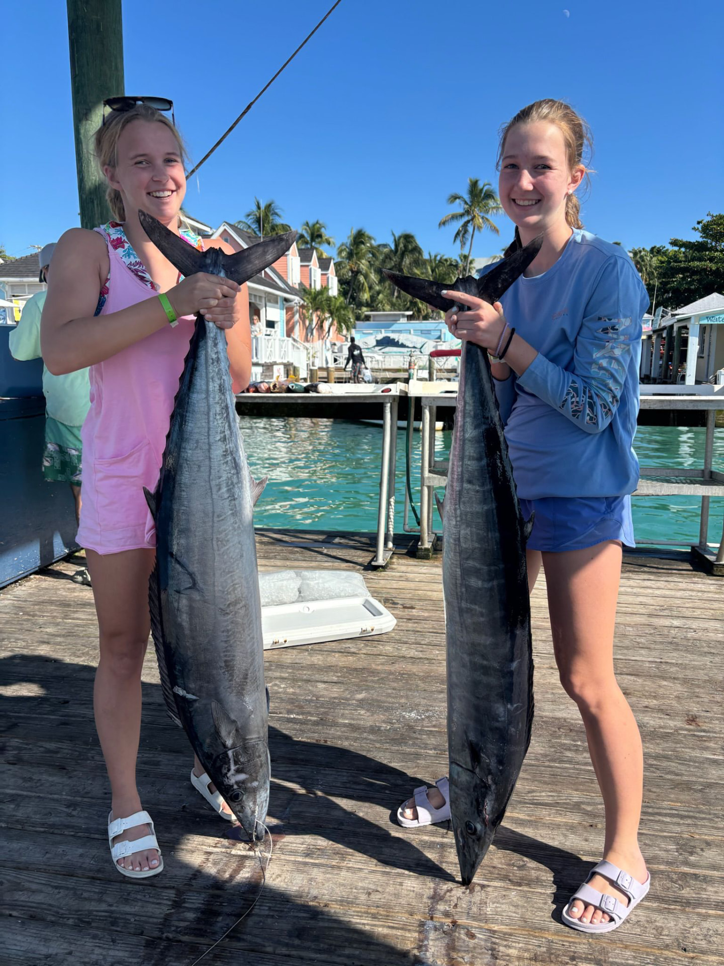 Young anglers holding a large fish on the Harbour Island dock