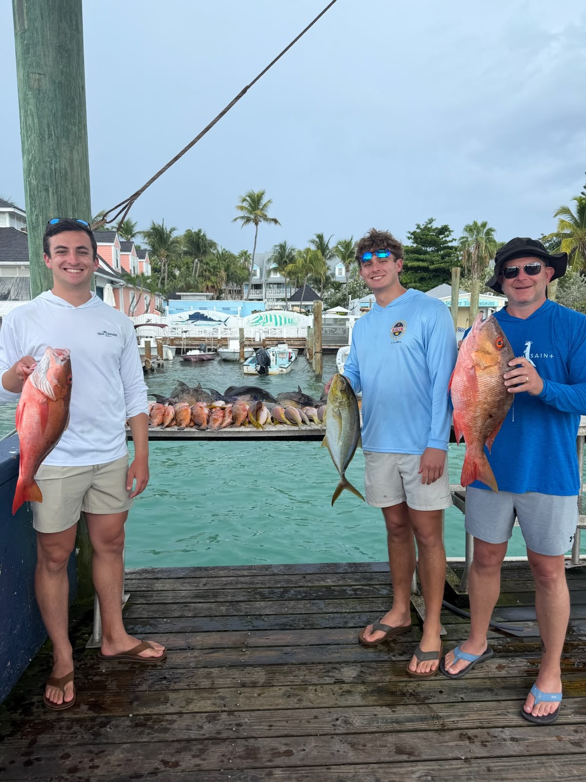 Guests holding their catch on the dock at Harbour Island